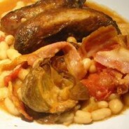 Recipe for sausages baked on a nest of cannellini beans, hot smoked garlic and bacon